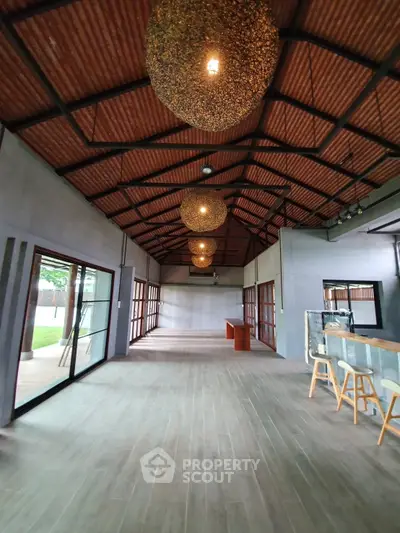 Spacious open-plan interior with high ceilings and modern lighting, perfect for versatile living or commercial use.