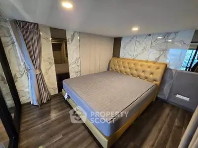 Luxurious bedroom with elegant marble walls and plush bed in modern apartment.