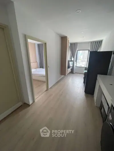 Modern apartment interior with bedroom and city view, featuring sleek design and natural light.