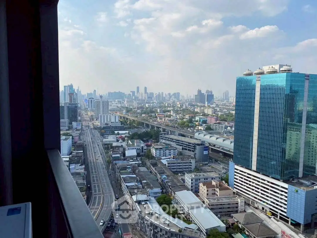 Stunning cityscape view from high-rise balcony with modern skyscrapers and blue sky.