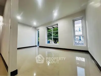 Spacious and bright room with large windows and glossy tiled flooring