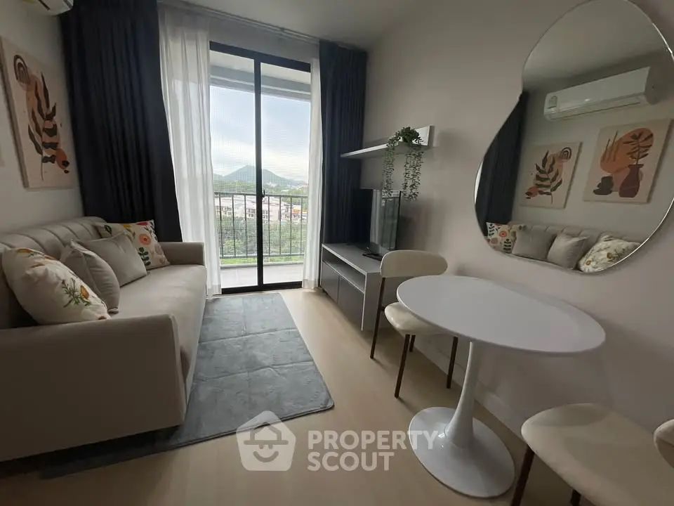 Modern living room with balcony view, stylish decor, and cozy seating area.