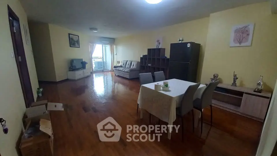 Spacious living room with dining area and balcony access in modern apartment.