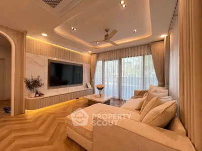 Luxurious living room with elegant decor and large TV, featuring cozy seating and ambient lighting.