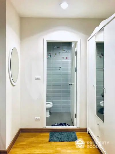 Pristine bathroom with modern fixtures, glass shower enclosure, and elegant tiling, complemented by a large mirror and warm lighting.