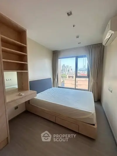 Modern bedroom with city view, featuring built-in shelves and air conditioning.