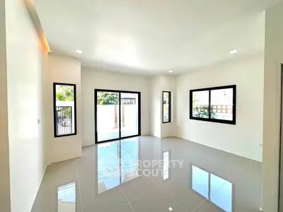 Spacious modern living room with large windows and glossy tiled floors