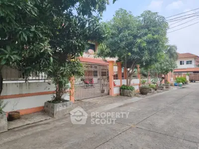 Charming suburban home with gated entrance and lush greenery in a peaceful neighborhood.