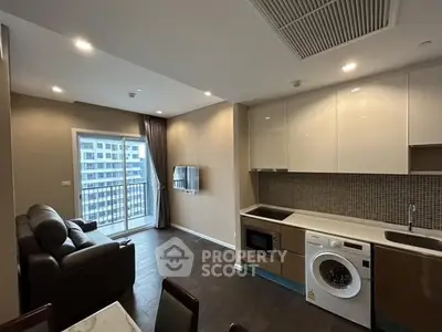 Modern living room with open kitchen and balcony view in a stylish apartment.