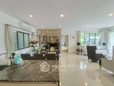 Spacious open-plan living room with modern decor and large windows