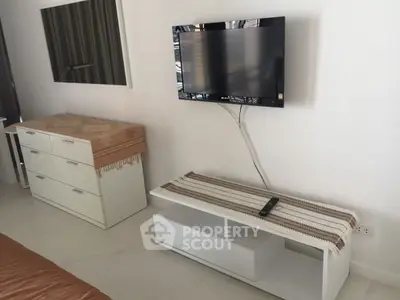 Modern living room with wall-mounted TV and sleek white furniture