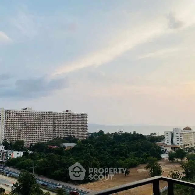 Stunning balcony view overlooking lush greenery and distant ocean horizon.