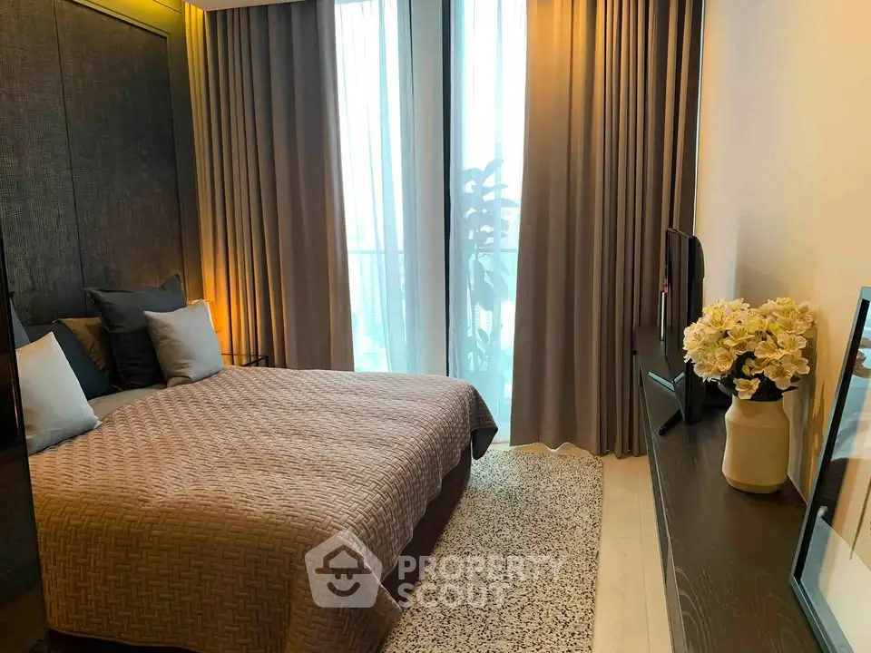 Modern bedroom with elegant decor and large window offering natural light.