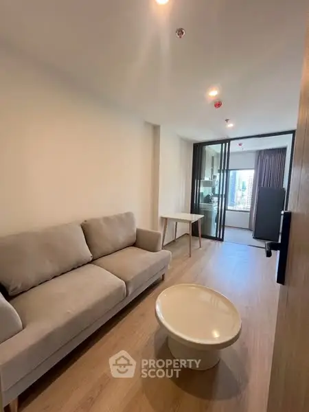 Modern living room with cozy sofa and stylish coffee table, featuring a bright open layout and wooden flooring.