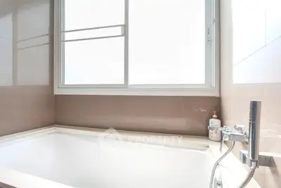 Modern bathroom with sleek bathtub and large window for natural light.