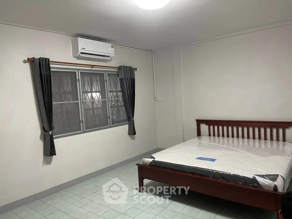 Spacious bedroom with air conditioning and natural light, perfect for comfort and relaxation.