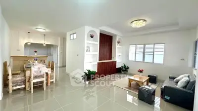 Spacious modern living room with dining area, elegant decor, and natural light.