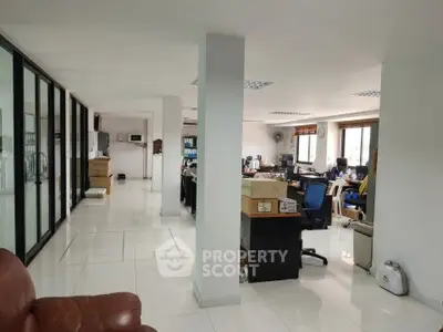 Spacious open-plan office with modern furnishings and ample natural light.