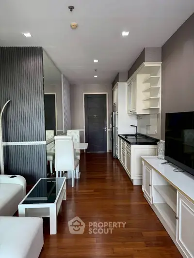 Modern living room with elegant dining area and sleek kitchen in open layout apartment.
