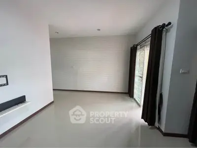 Spacious unfurnished room with large window and modern tile flooring, perfect for customization.