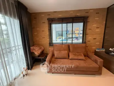 Cozy living room with brown sofa and large window, perfect for relaxation.