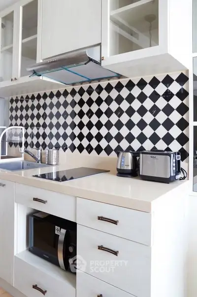 Modern kitchen with sleek appliances and stylish black-and-white backsplash
