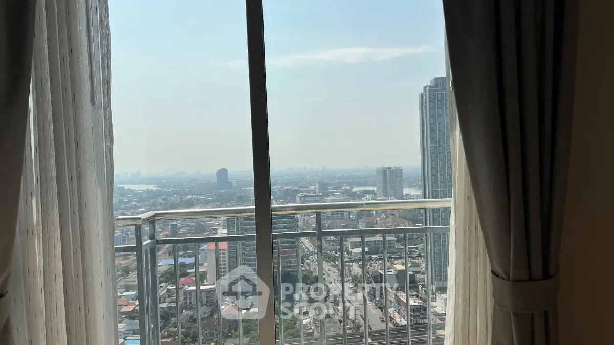 Stunning cityscape view from high-rise apartment balcony with elegant curtains.
