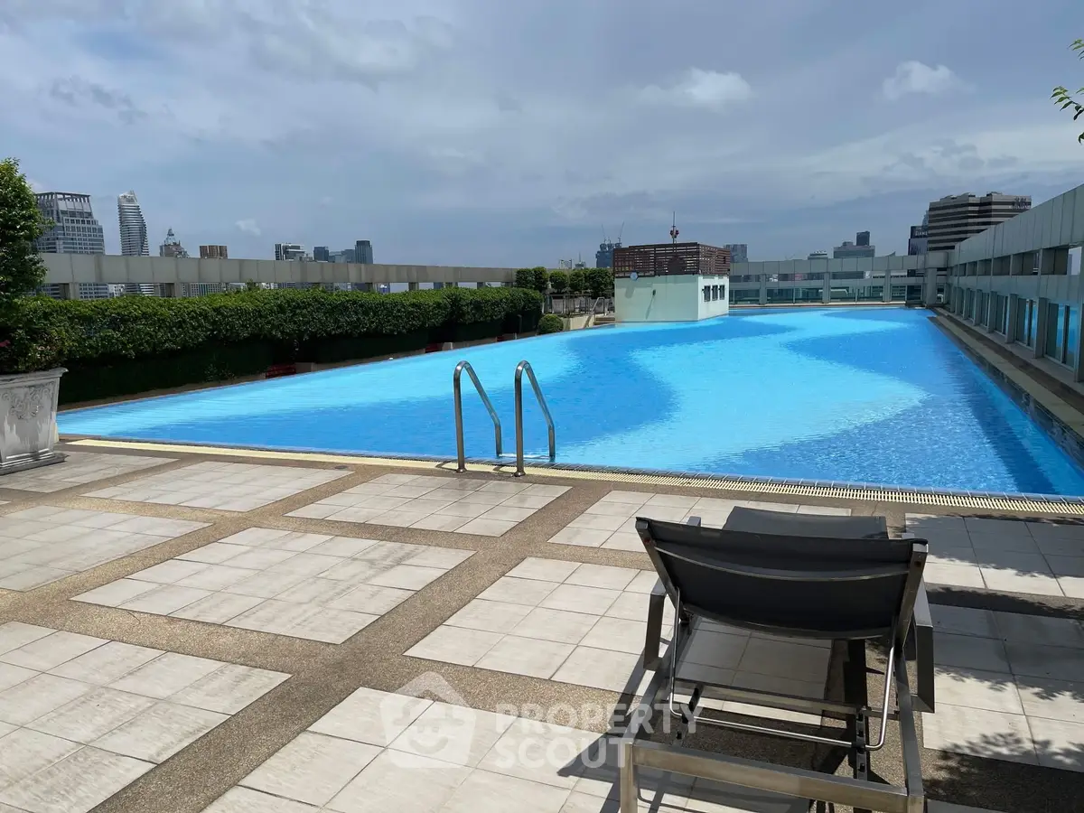 Luxurious rooftop pool with city skyline views and lounging area.