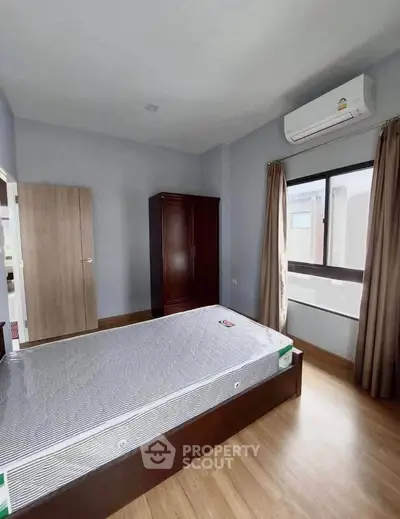 Spacious bedroom with air conditioning and wooden flooring