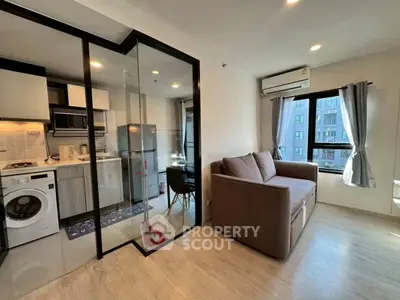 Modern apartment with glass partition, cozy living area, and sleek kitchen appliances.