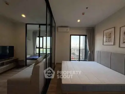 Modern bedroom with balcony and large glass partition, featuring a comfortable bed and stylish decor.