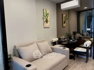 Modern living room with cozy sofa and dining area, featuring stylish decor and air conditioning.