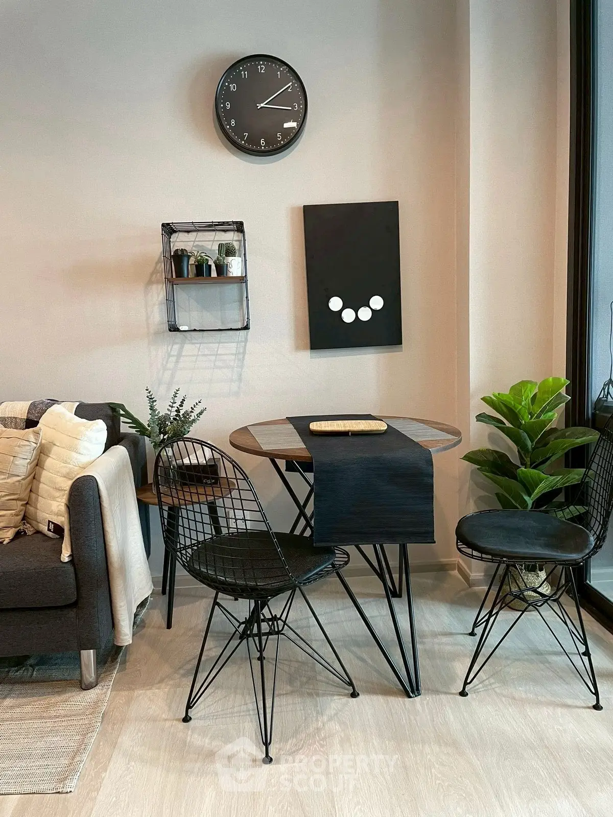 Modern living room with stylish furniture and decor, featuring a small dining table and chairs.