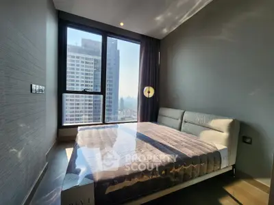 Modern bedroom with large window offering city view in high-rise apartment