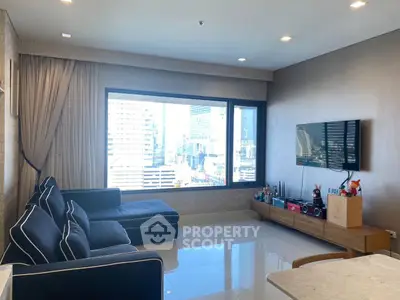 Modern living room with large window offering stunning city view, sleek furniture, and stylish decor.