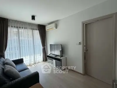 Modern living room with natural light, sleek furniture, and air conditioning in a stylish apartment.