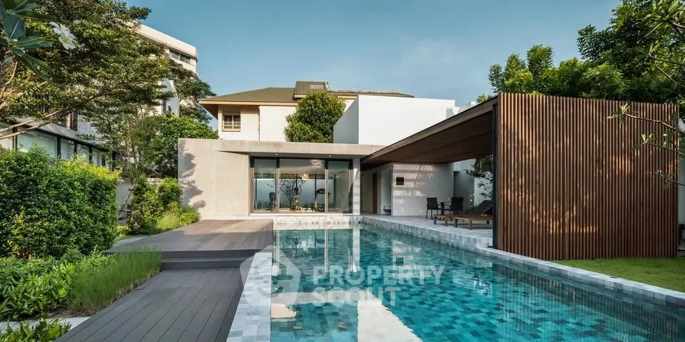Luxurious modern home with stunning pool and lush garden, perfect for relaxation and entertaining.