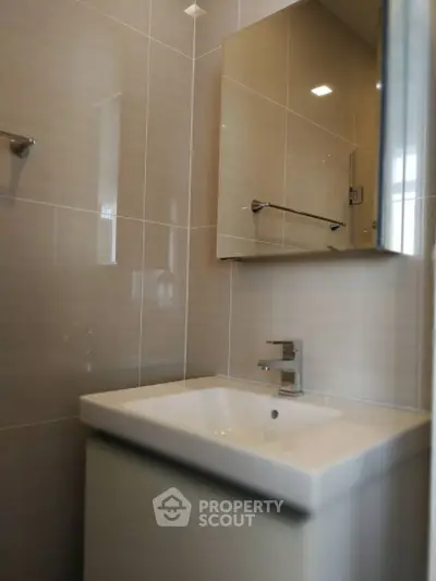 Modern bathroom with sleek sink and mirror in contemporary design.