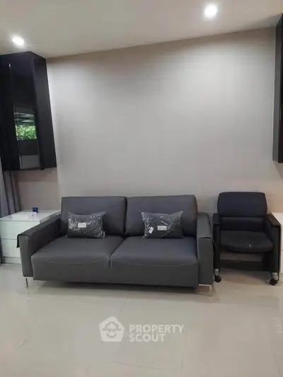 Modern living room with sleek gray sofa and armchair, perfect for contemporary urban living.