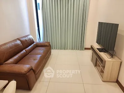 Cozy living room with leather sofa and modern TV setup, perfect for relaxation.