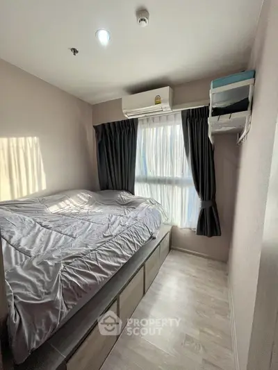 Cozy bedroom with natural light, featuring a large bed and modern air conditioning unit.