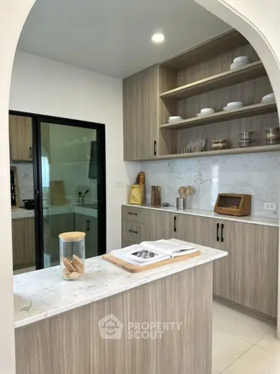 Modern kitchen with marble countertops and wooden cabinets, featuring open shelving and sleek design.