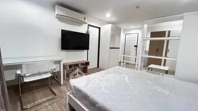 Modern bedroom with air conditioning, TV, and stylish furniture in a cozy apartment.