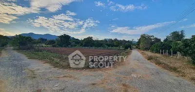 Scenic rural landscape with dirt roads and farmland under a blue sky, ideal for real estate development.