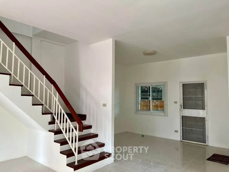 Spacious interior with modern staircase and tiled flooring, perfect for customization.