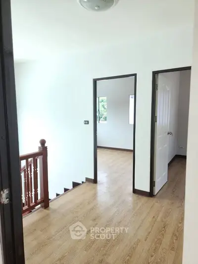 Bright hallway with wooden flooring and staircase in modern home