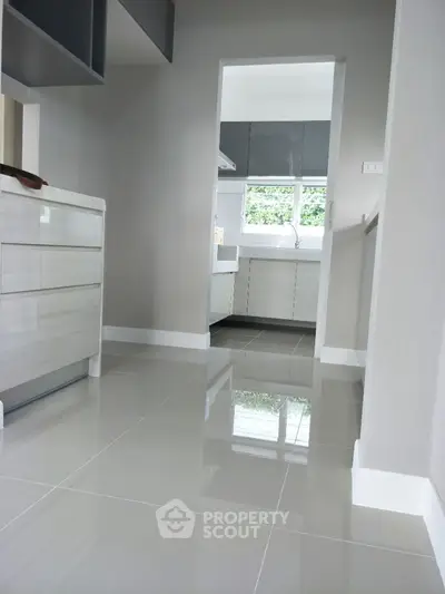 Modern kitchen with sleek cabinetry and glossy tile flooring