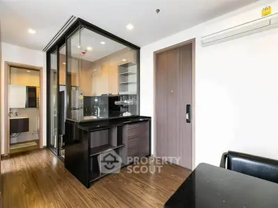 Modern apartment kitchen with sleek glass partition and wooden flooring