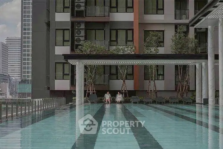 Luxurious apartment building with a stunning outdoor pool and city view, perfect for relaxation and leisure.