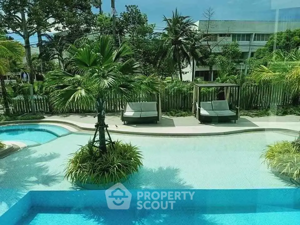 Luxurious poolside view with lush greenery and stylish loungers in a serene setting.